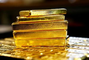 Gold dips 1% as dollar rises, but heads for quarterly gain