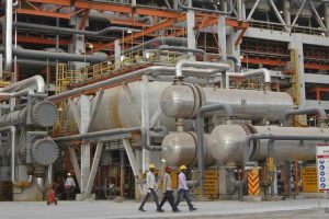 Workers walk inside the complex of the Vadinar refinery operated by Essar Oil Ltd. in Gujarat